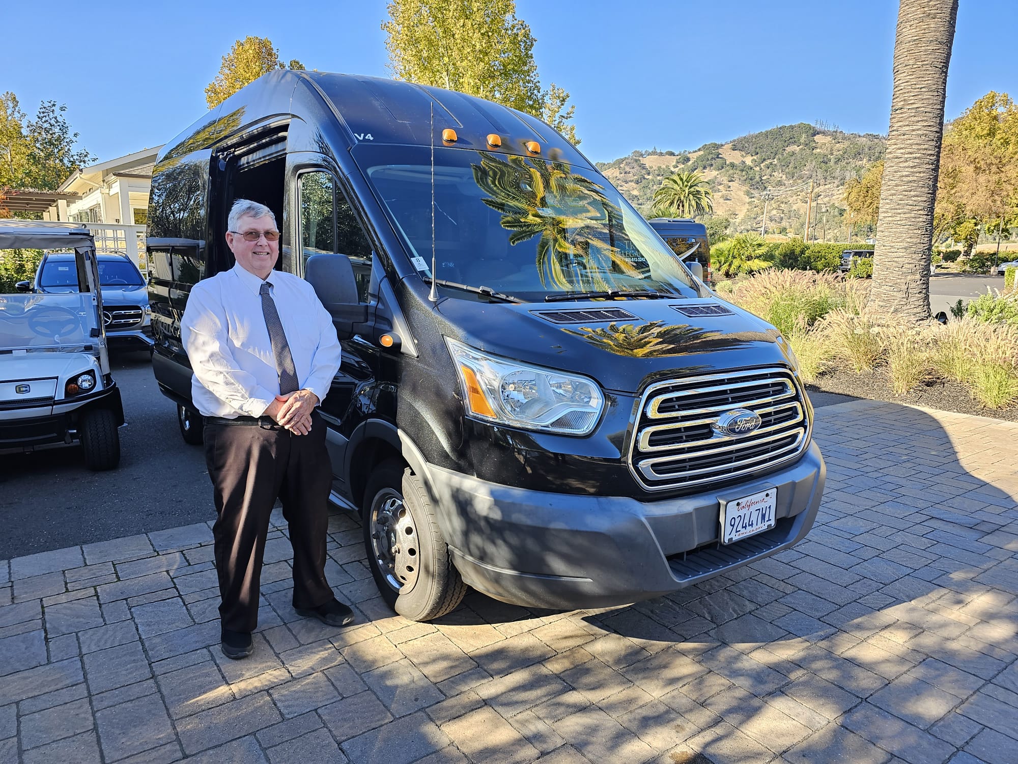 True Elegance chauffeur standing beside a black executive shuttle in Napa Valley